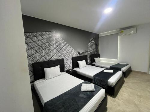 a room with two beds and a wall at Hotel Fenix in Cúcuta