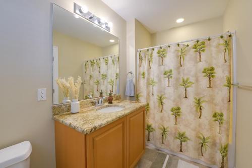 a bathroom with a sink and a shower curtain with palm trees at Spacious Wildwood Townhome with Covered Balcony in Wildwood