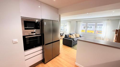 a kitchen with stainless steel appliances and a living room at Fogar de Breogan in A Coruña