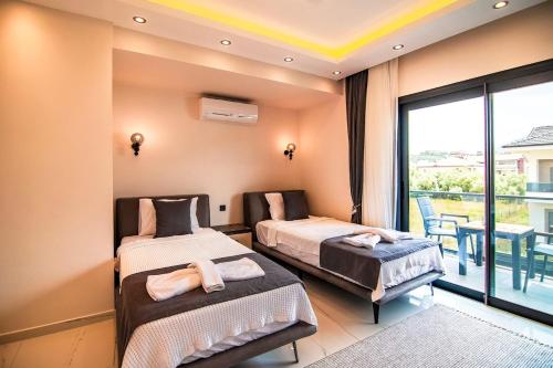 a bedroom with two beds and a balcony at Villa Unique 2 in Fethiye