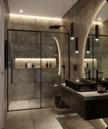 un bagno con doccia in vetro e lavandino di Gf Apartment a Pristina