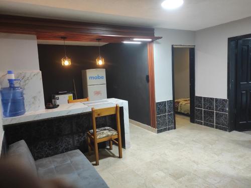 a room with a kitchen with a counter and a chair at Home Sweet Home Riobamba Chimborazo in Riobamba