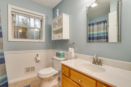 a bathroom with a toilet and a sink and a window at Fire Pit, Games and Outdoor Fun! Poconos Retreat in Blakeslee