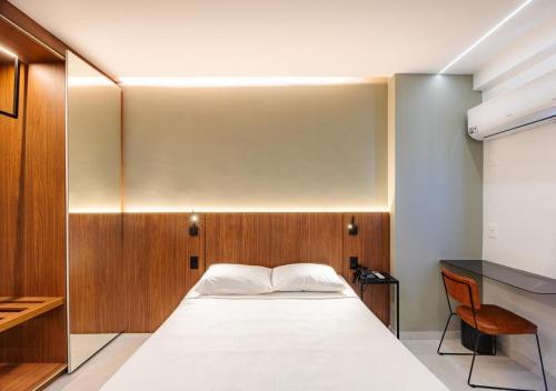 a bedroom with a white bed and a desk at Majestic Rio Palace Hotel in Rio de Janeiro