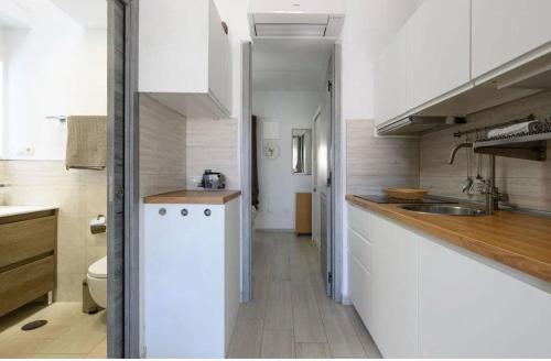 a kitchen with white cabinets and a white refrigerator at Maspalomas Lago 36 in Maspalomas
