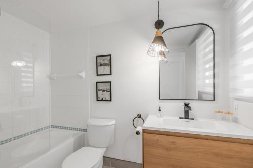 a bathroom with a toilet and a sink and a mirror at Hameau 26-33 studio in Stoneham