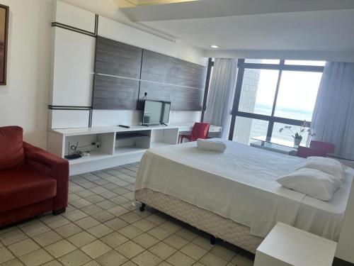 une chambre avec un lit, un bureau et une télévision dans l'établissement Suíte Golden Beach Frente Mar, à Récife