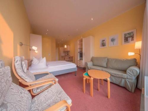 een woonkamer met een bed en een bank bij Elegant eingerichtete Ferienwohnung in Granzow