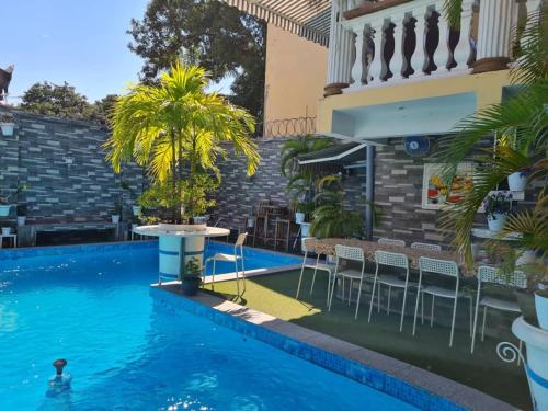 una piscina con sillas y una mesa junto a un edificio en 2 Bedroom Appartement in the City, en Kinshasa