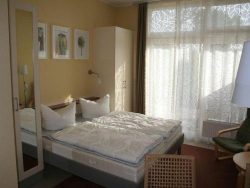 een bed in een kamer met een groot raam bij Appartement mit skandinavischem Flair in Granzow