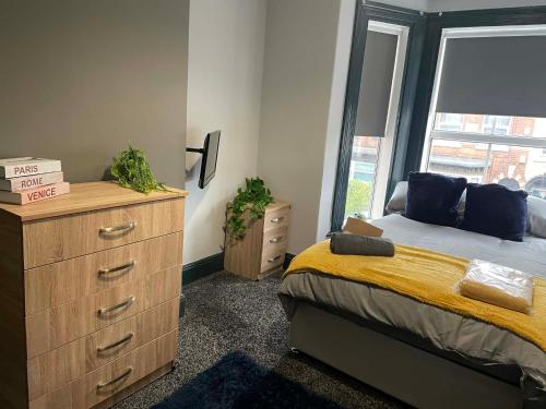 a bedroom with a bed and a dresser and a window at Allon Manor De'Grey in Hull