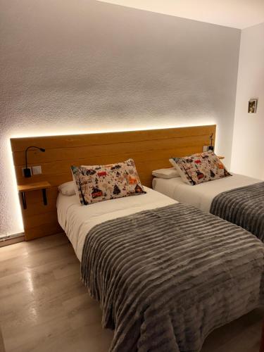 una camera d'albergo con due letti in una stanza di Apartamento La Pinada a Tramacastilla de Tena