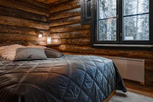 una camera con un letto in una baita di tronchi di Villa Kuurupiilo a Kuusamo