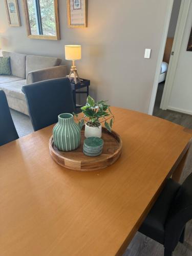 a wooden table with two vases on top of it at Resort Living with Pool, Golf, Bar and Dining in Fingal