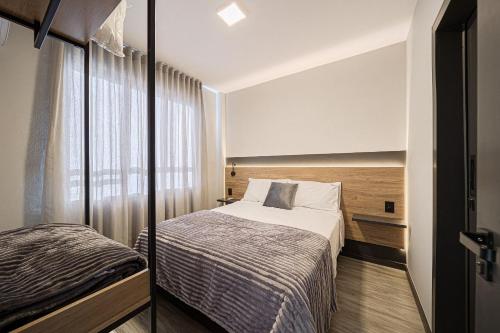 Design, Wi-Fi 7, 4 Hóspedes e Conforto Premium في Boa Vista: غرفة نوم صغيرة بها سرير ونافذة