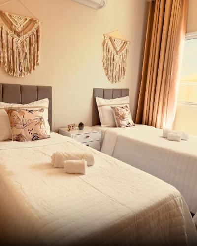 a bedroom with two beds and a window at SW Rustica Apartamentos in Canoa Quebrada