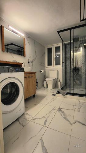 a bathroom with a washing machine and a toilet at Ethereal Kavala in Kavála