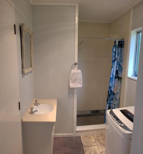 a white bathroom with a sink and a shower at Hydrangea Cottage in Marton in Marton