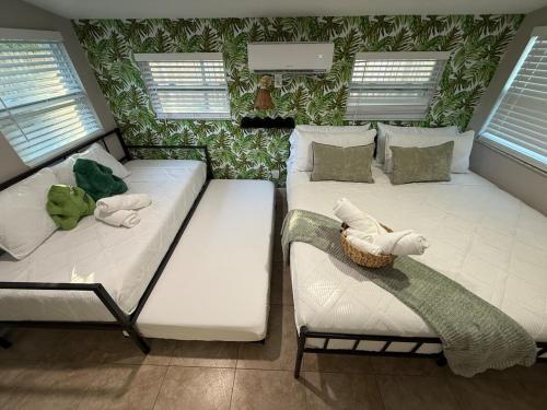 a room with two beds and a couch at 20 Off The Jungle House 10 min Beach & FLL Airport in Fort Lauderdale