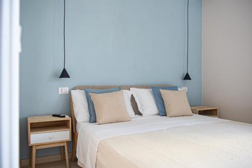 a bedroom with a white bed with blue walls at Marina Suite Elba in Marina di Campo