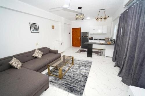 een woonkamer met een bank en een keuken bij Villa Pure Luxor in Luxor