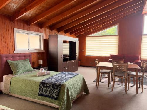 a bedroom with a bed and a table and chairs at Hotel Gran Luna in Puerto Montt