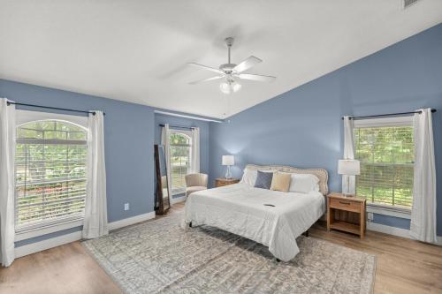 a blue bedroom with a bed and two windows at Citrus Springs Oasis-Rainbow River, Manatees, Golf in Citrus Springs