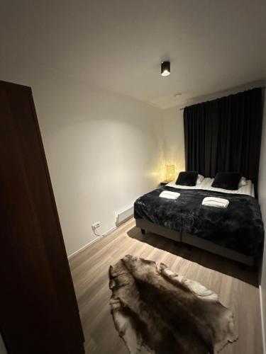 Un dormitorio con una cama y una alfombra en el suelo. en Arctic Glow Apartment 3, en Ivalo