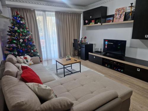 a living room with a christmas tree and a couch at WRW Airport Residence in Otopeni