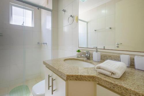 a bathroom with a sink and a toilet and a mirror at MTCA041 - Localização Perfeita! 3Q+2WC+2 vagas in Balneário Camboriú