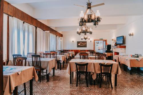 San Pedro Hotel في ريو سيبالوس: غرفة طعام مع طاولات وكراسي وثريا