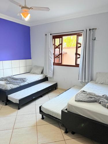 a room with three beds and a window at Sossego Ponta da Fruta in Vila Velha