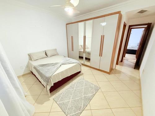 una camera da letto con un letto e una porta scorrevole in vetro di Sossego Ponta da Fruta a Vila Velha