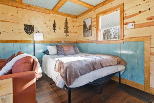 a bedroom with a bed in a wooden cabin at NEW! BEAR Necessities tiny home, outdoor theater! in Garrison