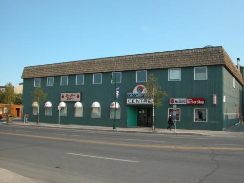 a green building on the corner of a street at Discovery Inn in Yellowknife