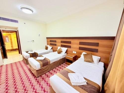 a hotel room with three beds in it at Mizab Hotel From Nebras Alhuda in An Naqāʼ
