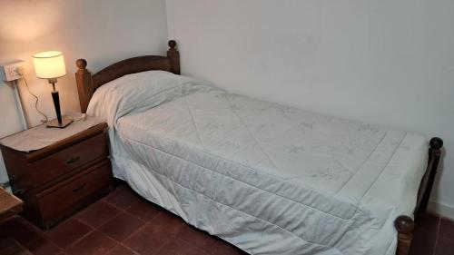 a bedroom with a bed and a night stand with a lamp at Casa Julia in Puerto Madryn