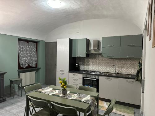 a kitchen with a table and a kitchen with green cabinets at Verde Speranza Apartment in Crescentino