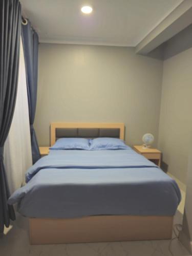 a bedroom with a bed with a blue blanket at SBJ's Home in Entebbe