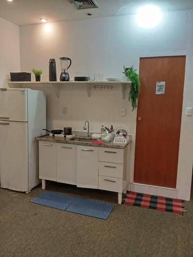 Una pequeña cocina con fregadero y refrigerador. en Studio, en Río de Janeiro