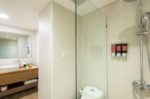 a bathroom with a shower and a toilet and a sink at Cozy 2BD Condo, Near Beach in San Felipe de Puerto Plata