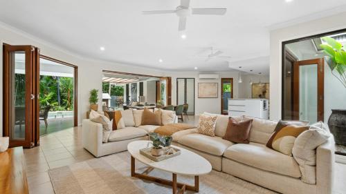 een woonkamer met twee banken en een tafel bij Shambala at Palm Cove in Palm Beach