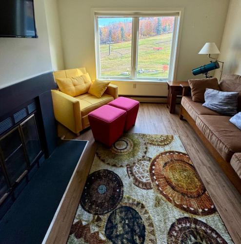 a living room with a couch and a fireplace at Magic Mountain Ski Resort in Londonderry