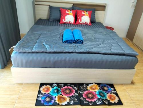 a bed with blue flip flops and flowers on it at Abu Sea Man House in Ko Lanta Yai