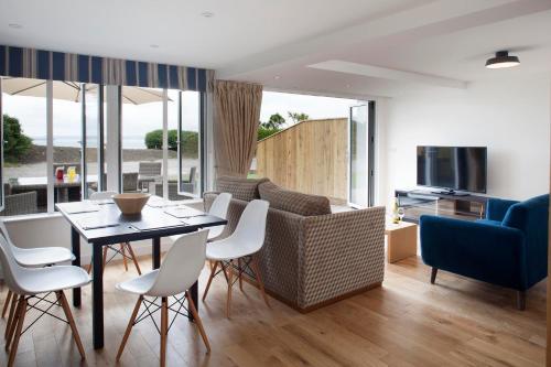 a dining room and living room with a table and chairs at Falmouth Self Catering Lodges in Falmouth