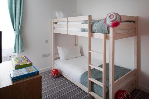 a bedroom with two bunk beds and a desk at Falmouth Self Catering Lodges in Falmouth