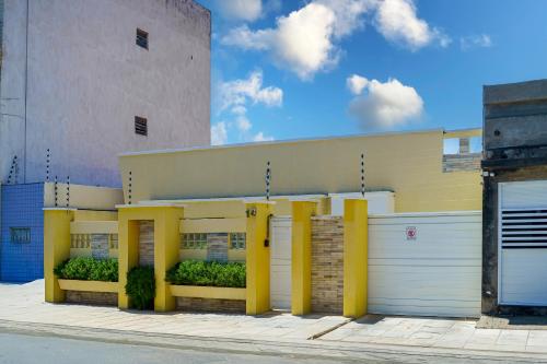 un edificio con pilares amarillos delante de él en Pousada Sousa Residencial Qrt2, en Sousa