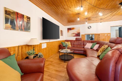 a living room with a couch and a flat screen tv at VILA FAMELIA VALTICE Adults Only in Valtice