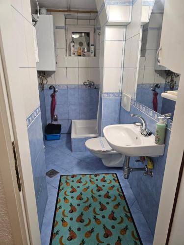 a blue and white bathroom with a sink and a toilet at Happy apartment-OldTown Sarajevo in Sarajevo