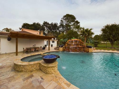 a swimming pool with a water slide in a yard at Buckle n Boots BNB - 20 minutes to downtown and pool in Houston
